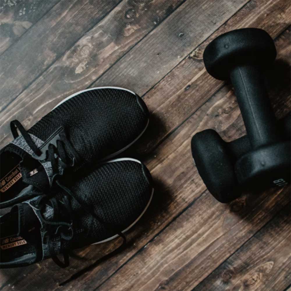 Barbells and sneakers on a wood floor
