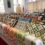 50 quilts draped over the pews in the North Chatham United Methodist Church