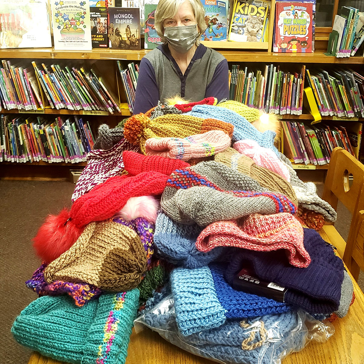 Pile of beautiful, new hats donated for hatsgiving and displayed on a library table